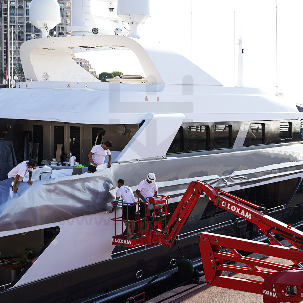 LuxWrap team installing silver vinyl on the superstructure of a 47m Swiftships superyacht using harness access